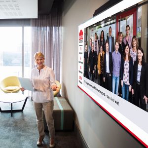 Frau in Präsentationssituation vor Leinwand